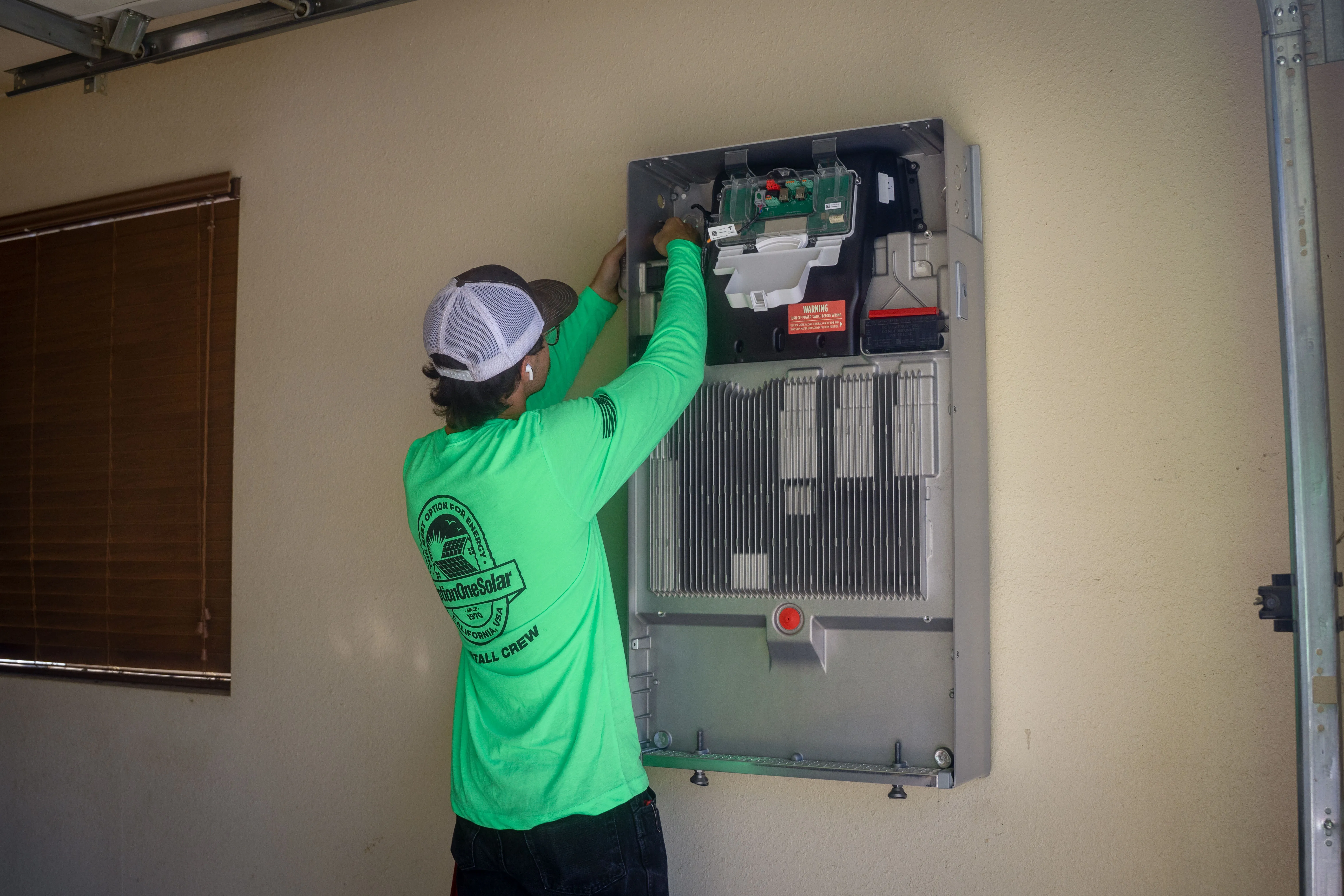 Option One Solar tech installing a Tesla Powerwall 3 residential battery